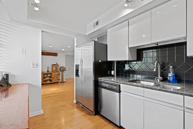 a kitchen with stainless steel appliances granite countertop a stove and a wooden floors