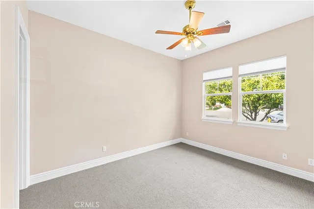 an empty room with a window and a fan