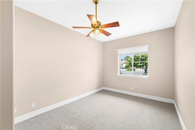 an empty room with a window and a fan