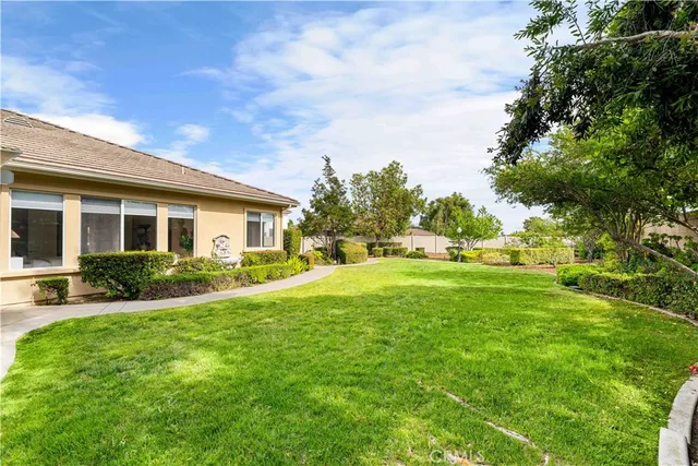 a view of a house with backyard and a garden