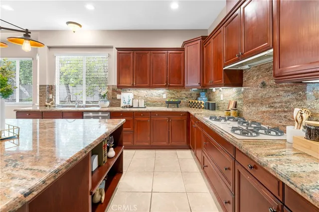 a large kitchen with stainless steel appliances granite countertop a sink counter space cabinets and a large window