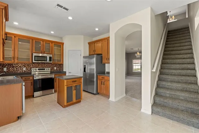 a kitchen with stainless steel appliances kitchen island granite countertop a stove and a refrigerator