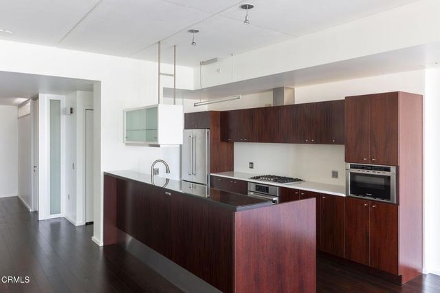 a view of a kitchen with a refrigerator and a stove top oven