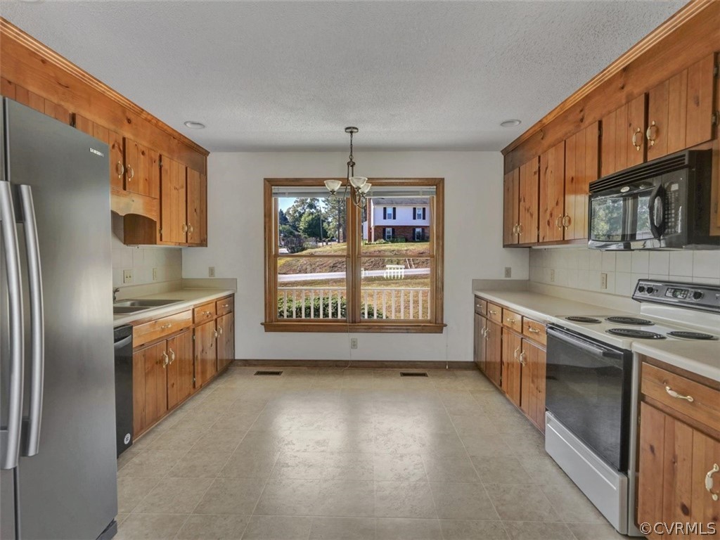 7936 Concho Road North Chesterfield, VA 23237 - Photo 9 of 24 a kitchen with stainless steel appliances granite countertop a stove a sink and a refrigerator