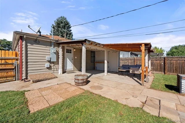 a view of a patio with table and chairs and wooden fence