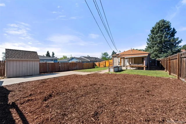 a view of a house with backyard and a tree
