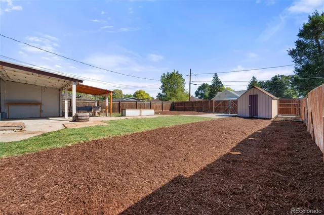 a view of a house with backyard and trees