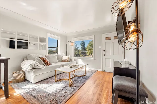 a living room with furniture a rug and wooden floor