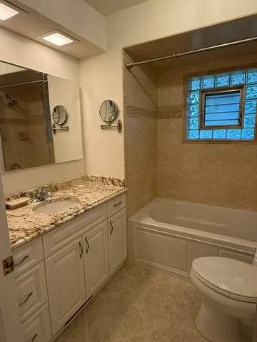 a bathroom with a granite countertop toilet a sink and bathtub