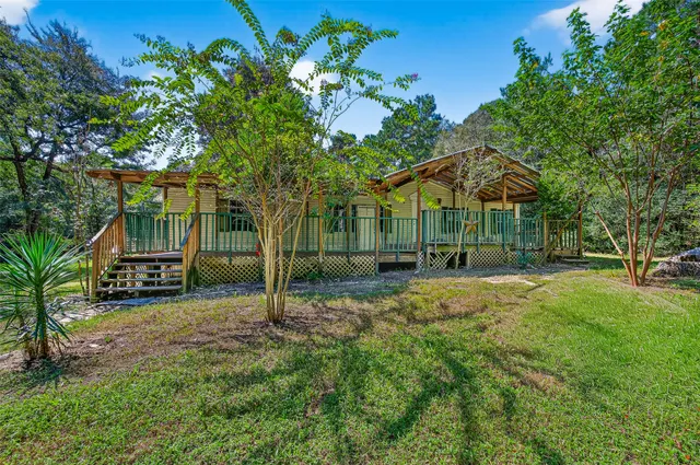 a view of a house with backyard and tree