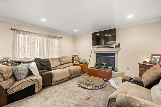 a living room with furniture a fireplace and a flat screen tv