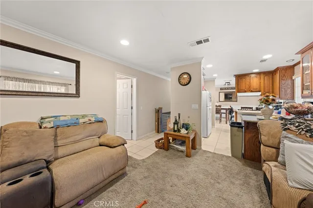 a living room with furniture and a view of kitchen