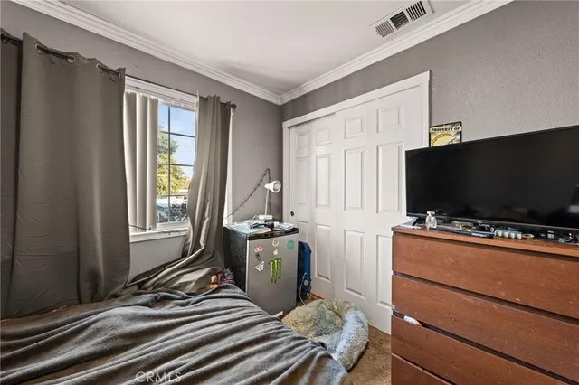 a bedroom with a bed and a flat screen tv