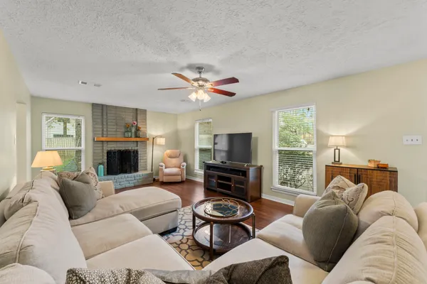 a living room with furniture a fireplace and a flat screen tv