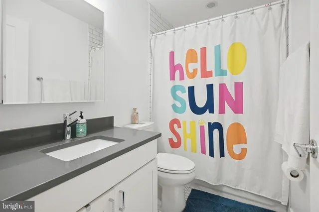 a bathroom with a sink mirror vanity and toilet