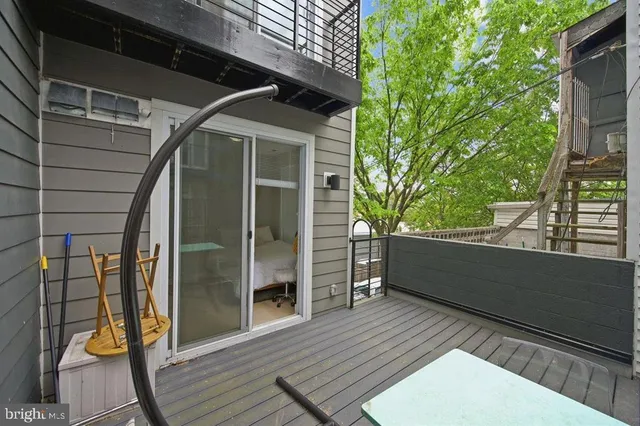 a view of a balcony with wooden floor and iron stairs