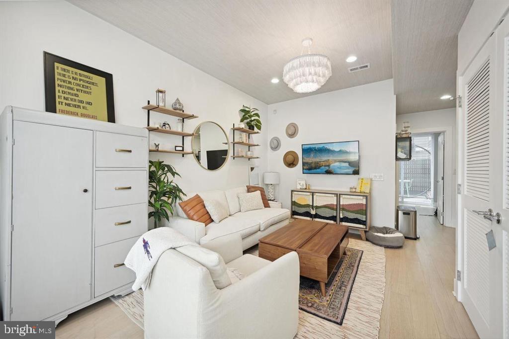 4016 Georgia Avenue Northwest, Unit 4 Washington, DC 20011 - Photo 2 of 13 a living room with furniture and a chandelier