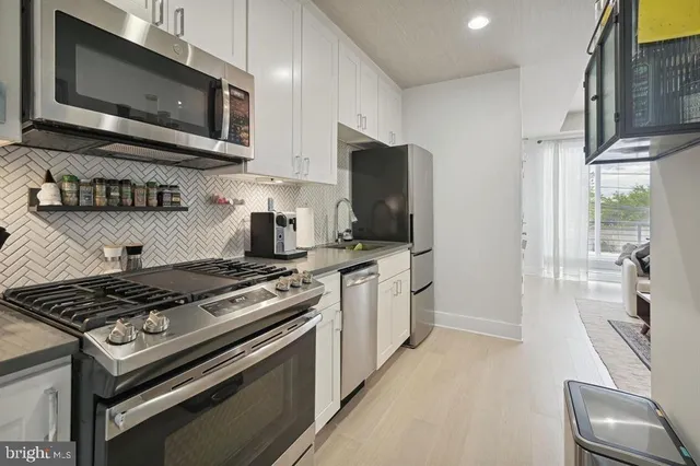 a kitchen with stainless steel appliances a stove a microwave a sink and cabinets