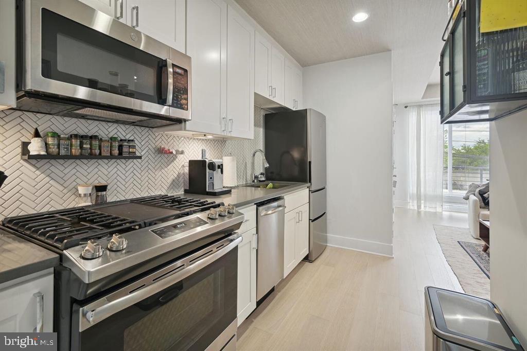 4016 Georgia Avenue Northwest, Unit 4 Washington, DC 20011 - Photo 5 of 13 a kitchen with stainless steel appliances a stove a microwave a sink and cabinets