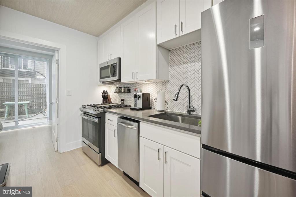 4016 Georgia Avenue Northwest, Unit 4 Washington, DC 20011 - Photo 6 of 13 a kitchen with stainless steel appliances granite countertop a sink stove and refrigerator