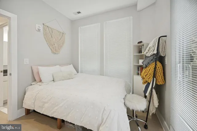 a bedroom with a bed a chandelier and a mirror