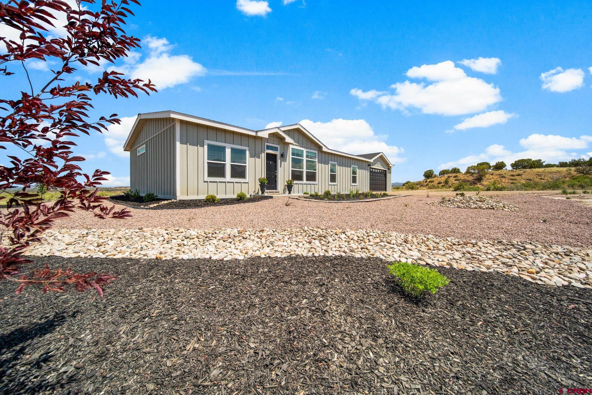 8476 Rd 30.6 Cortez Co 81321 Cortez, CO 81321 - Photo 2 of 30 a front view of a house with a garden and yard