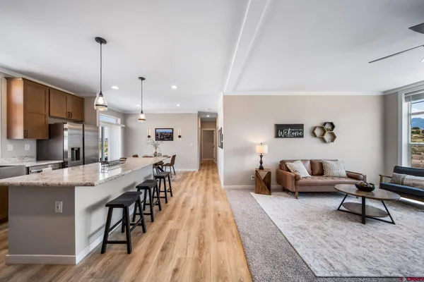 a living room with furniture a wooden floor and a chandelier