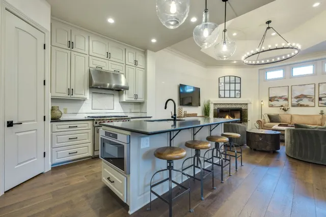 a kitchen with stainless steel appliances granite countertop a sink a stove and a refrigerator