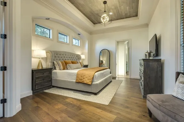 a bedroom with bed and wooden floor