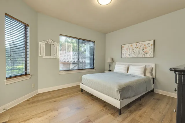 a bedroom with a large bed and a flat tv screen on dresser