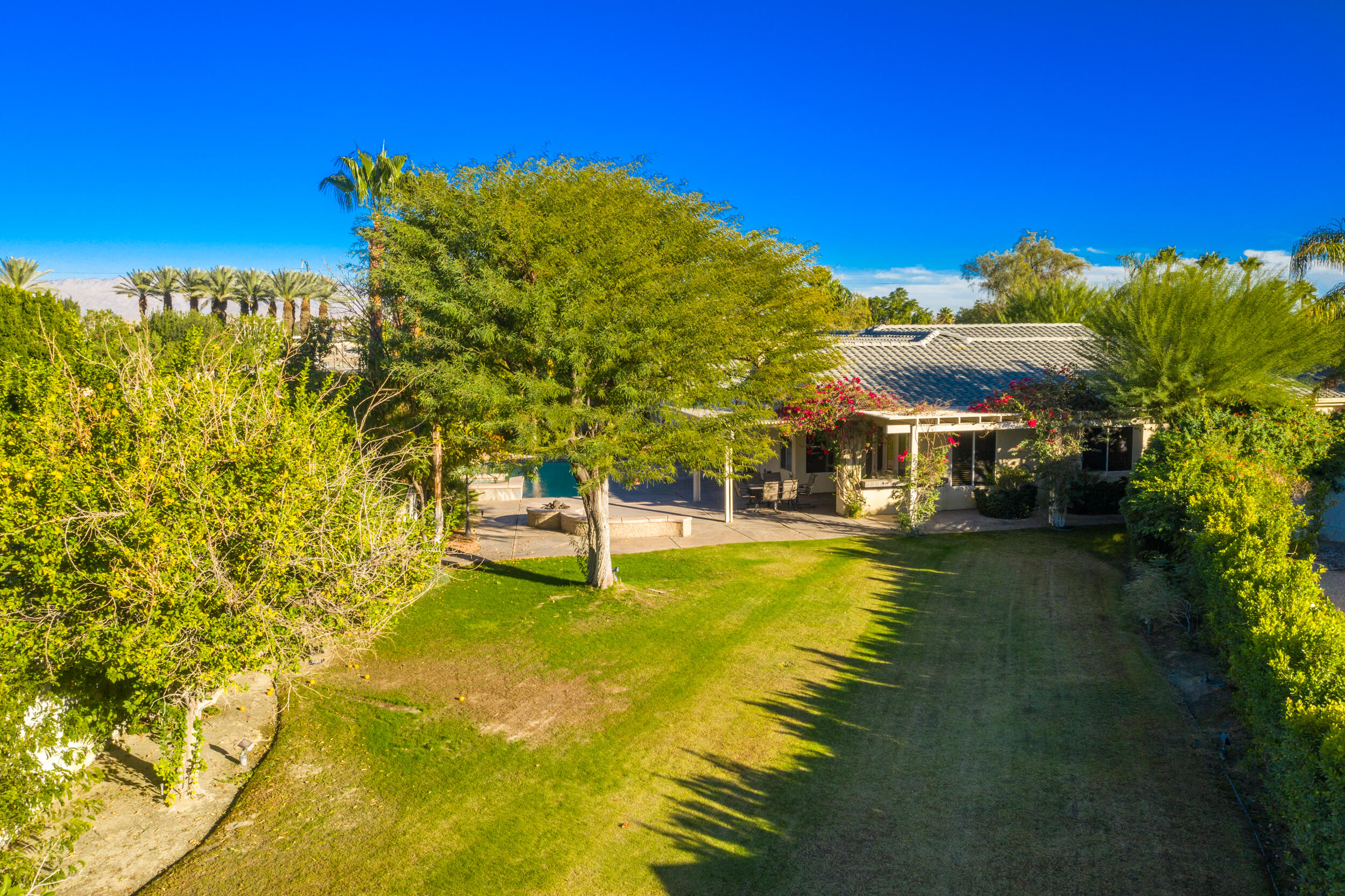 8 Trafalgar Rancho Mirage, CA 92270 - Photo 40 of 41 a view of a swimming pool with lawn chairs under an umbrella