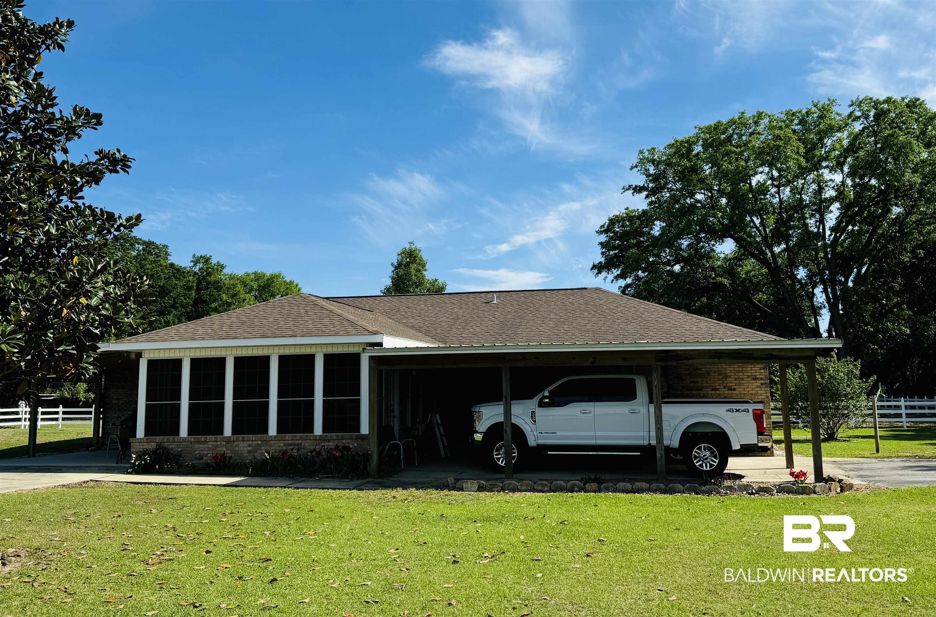 13795 White Road Silverhill, AL 36576 - Photo 57 of 99 View of side of property with a shingled roof, a sunroom, a carport, and stone siding