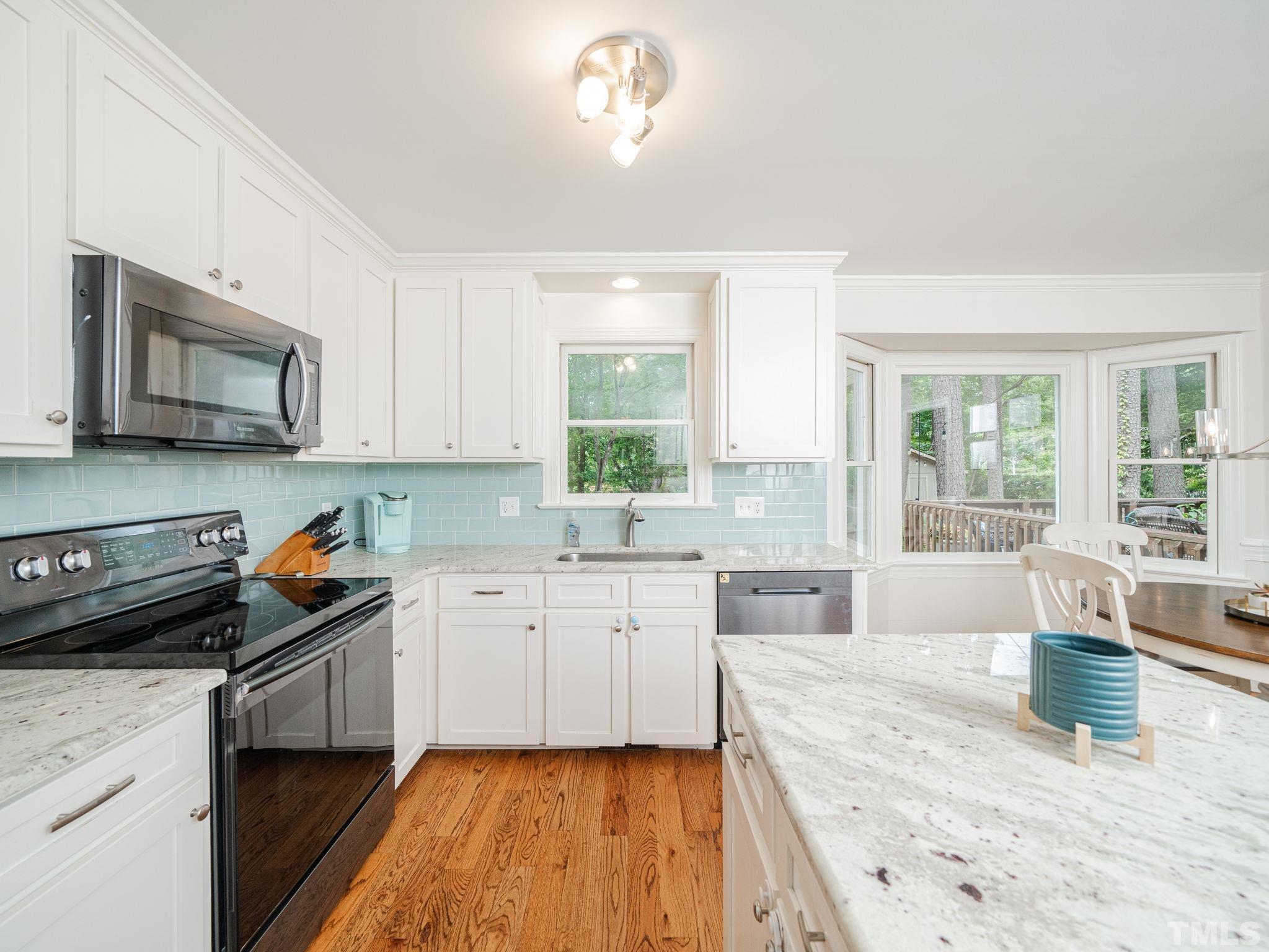 5029 Trail Ridge Drive Raleigh, NC 27613 - Photo 3 of 37 a kitchen with granite countertop a stove a sink and a microwave
