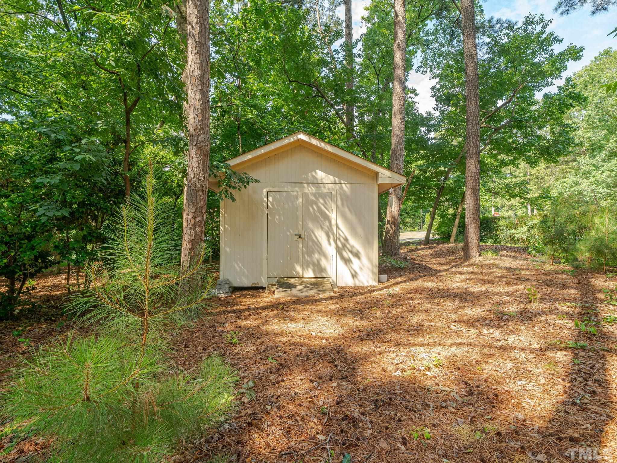 5029 Trail Ridge Drive Raleigh, NC 27613 - Photo 32 of 37 a backyard of a house with large trees and plants