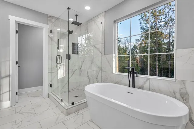 a white bath tub sitting next to a shower