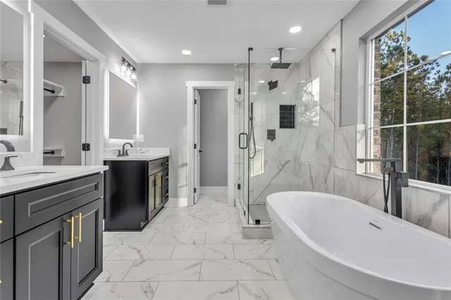 a large spacious bathroom with a tub sink shower and mirror