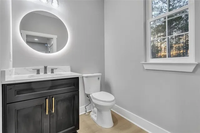 a bathroom with a toilet a sink and mirror