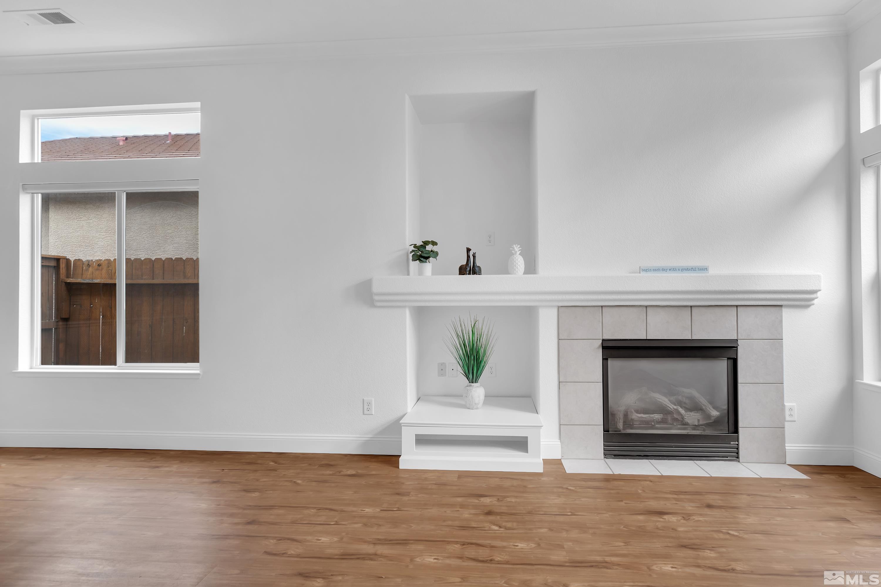 10445 Arbor Way Reno, NV 89521 - Photo 12 of 39 a view of an empty room with a fireplace and wooden floor