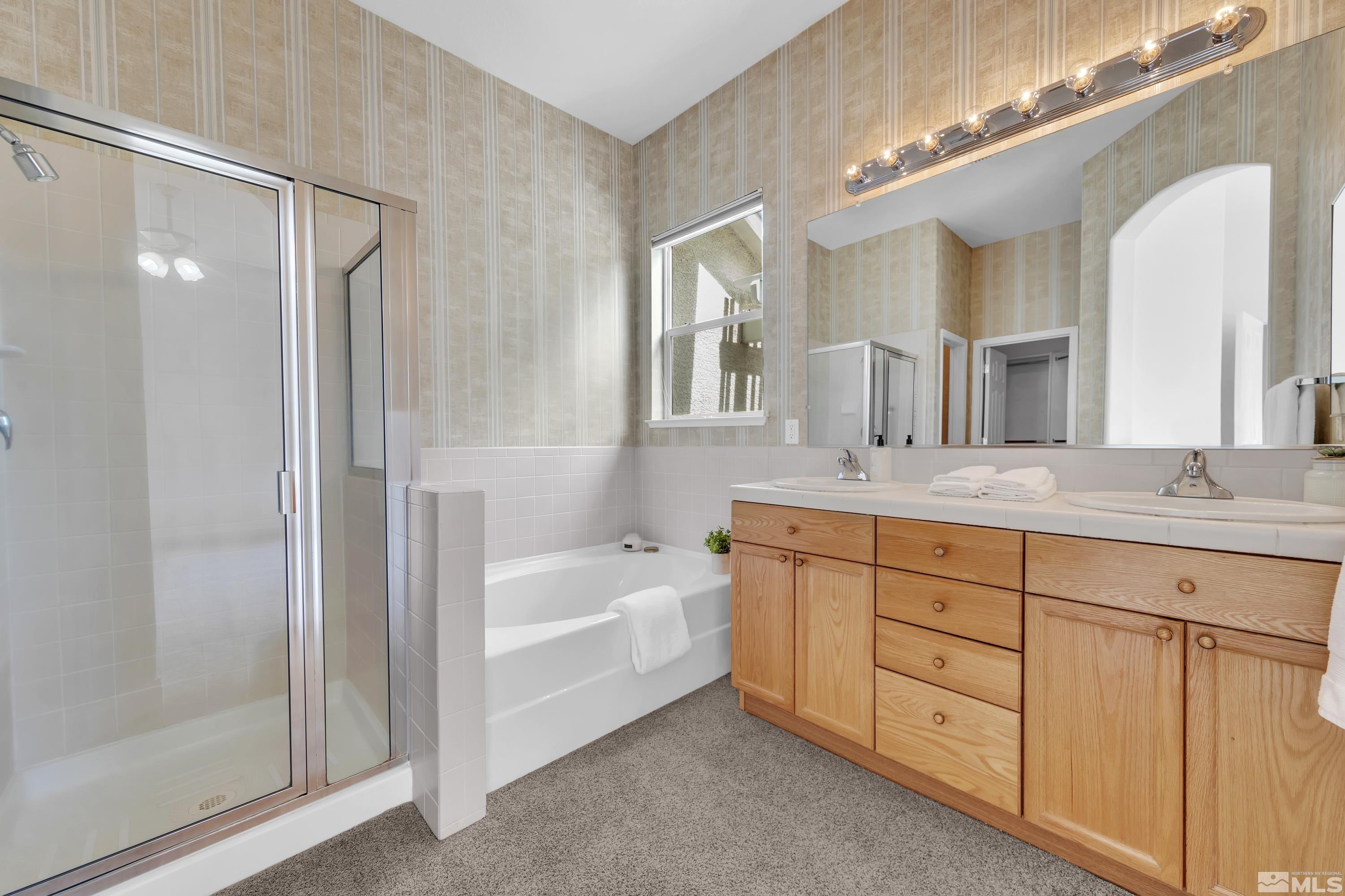 10445 Arbor Way Reno, NV 89521 - Photo 30 of 39 a spacious bathroom with a double vanity sink a large mirror and shower
