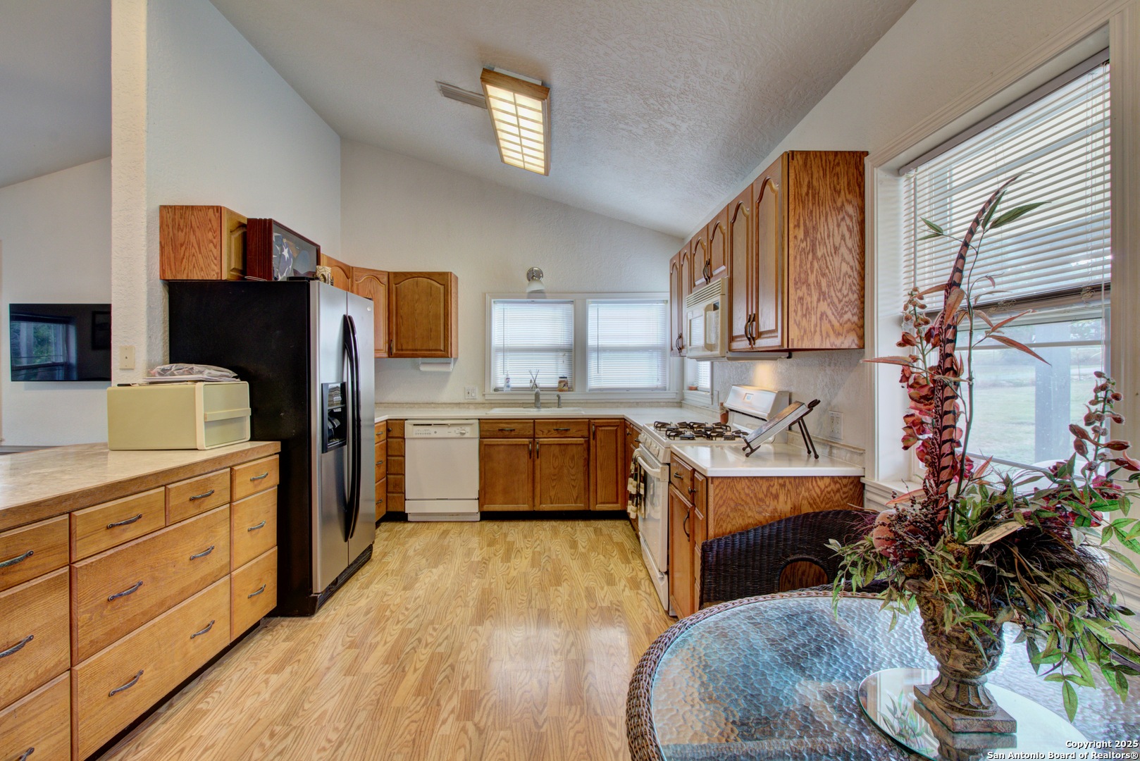 6248 Yorkshire Drive Spring Branch, TX 78070 - Photo 5 of 28 a kitchen with stainless steel appliances kitchen island granite countertop a stove a sink dishwasher and a refrigerator with wooden floor