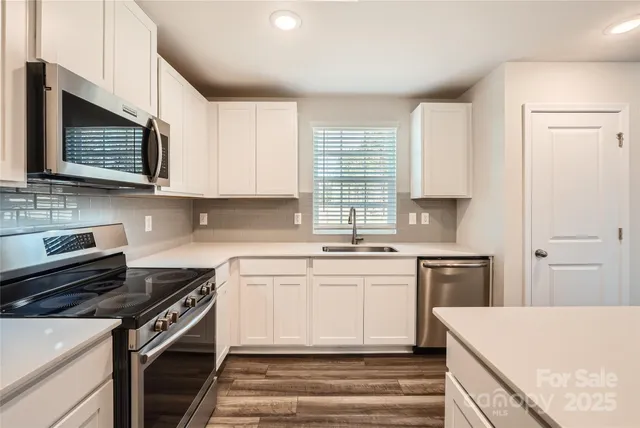 a kitchen with stainless steel appliances granite countertop a stove microwave and sink