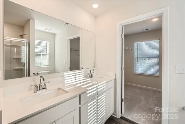 a bathroom with double vanity sinks and a mirror