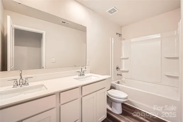 a bathroom with a granite countertop sink toilet a mirror and shower