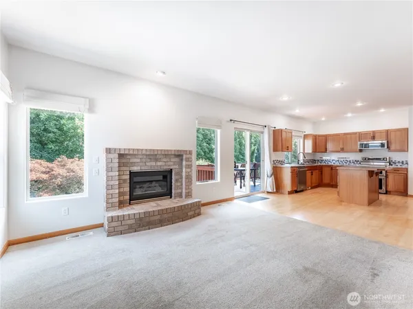 a view of an empty room with a fireplace and a window