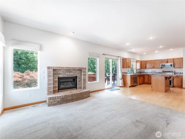 a view of an empty room with a fireplace and a window