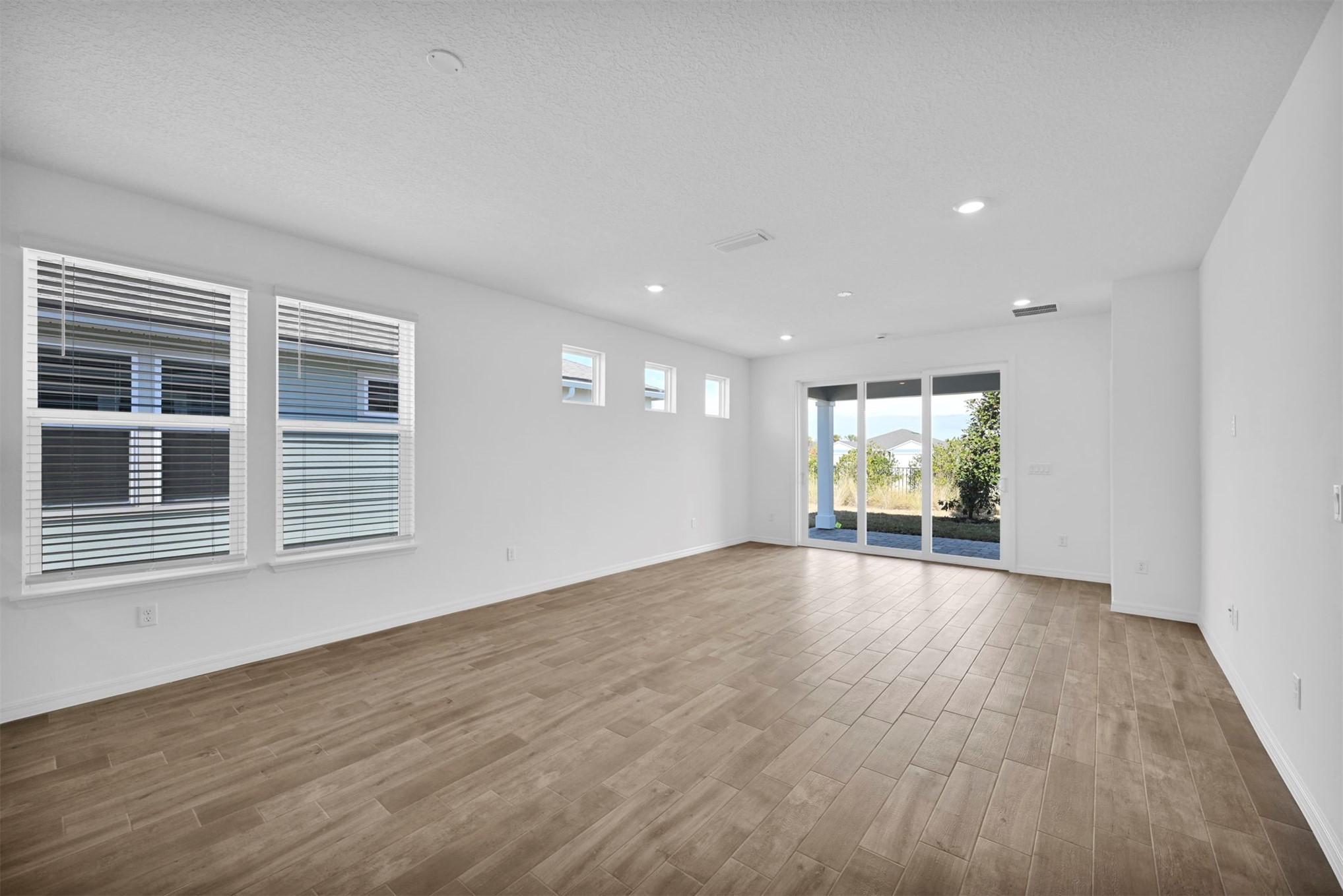 285 Ecliptic Loop Yulee, FL 32097 - Photo 8 of 42 a view of an empty room with wooden floor and a window