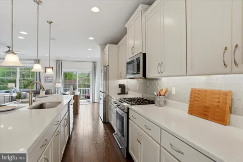 a kitchen with kitchen island granite countertop a sink a counter top space stainless steel appliances and cabinets