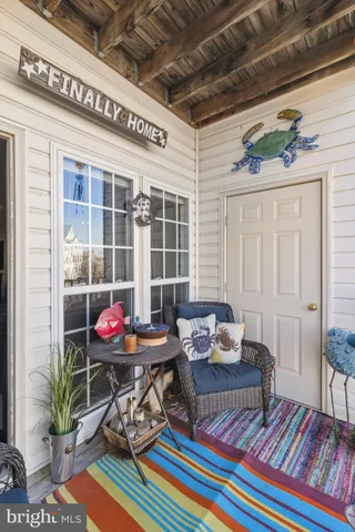 a living room with patio furniture and a potted plant