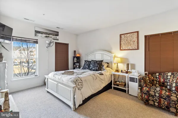 a bedroom with a bed couch and window