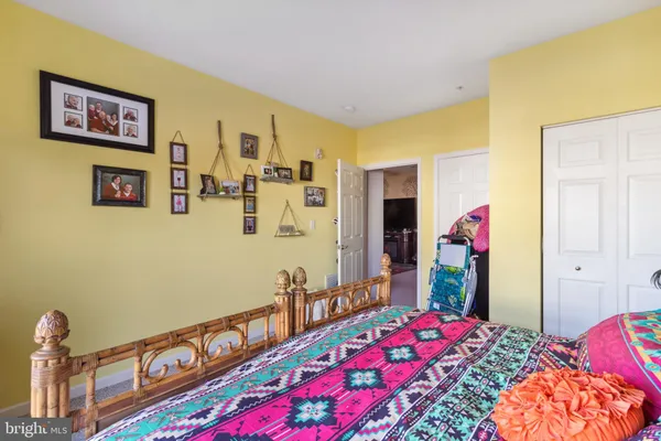 a bedroom with bed and paintings on the wall